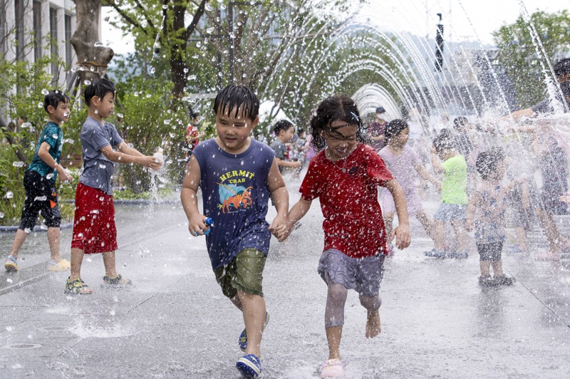 南韓生育率連續第6年下降，已成全球最低，圖為南韓首爾孩童在噴水池戲水消暑。新華社