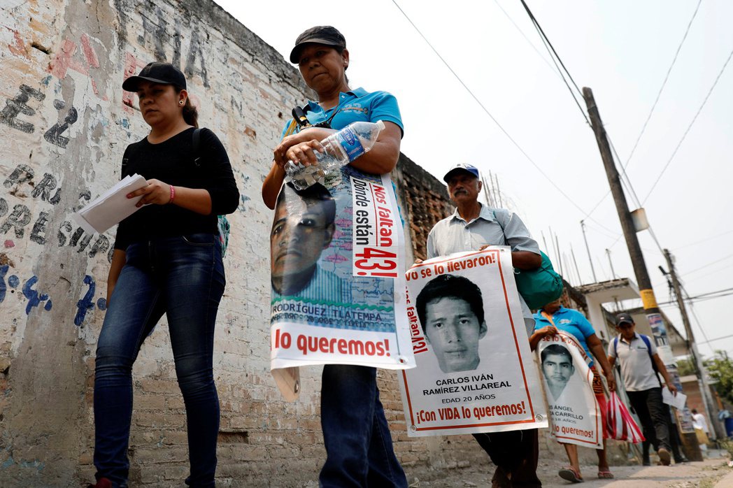 阿約欽納帕師範學校的教師們舉著失蹤學生的照片，上街抗議示威。 圖／路透社 