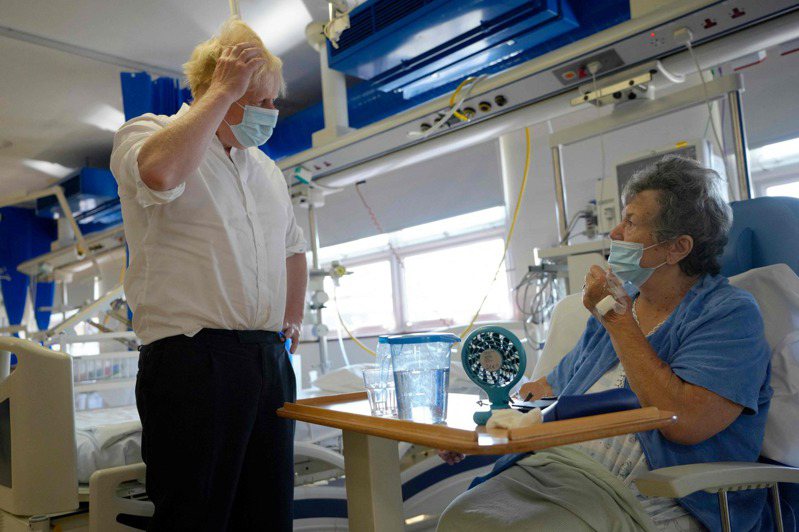 即将离任首相职位的强生（左）26日造访伦敦南郊埃普索姆一间骨科中心并与病患聊天。法新社(photo:UDN)