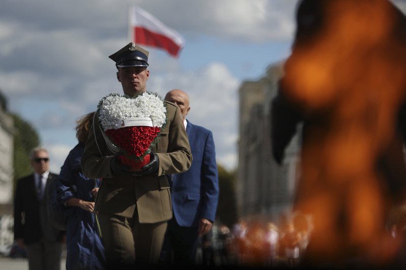 图为一名波兰士兵拿着花圈，参加二战週年纪念仪式。美联社(photo:UDN)