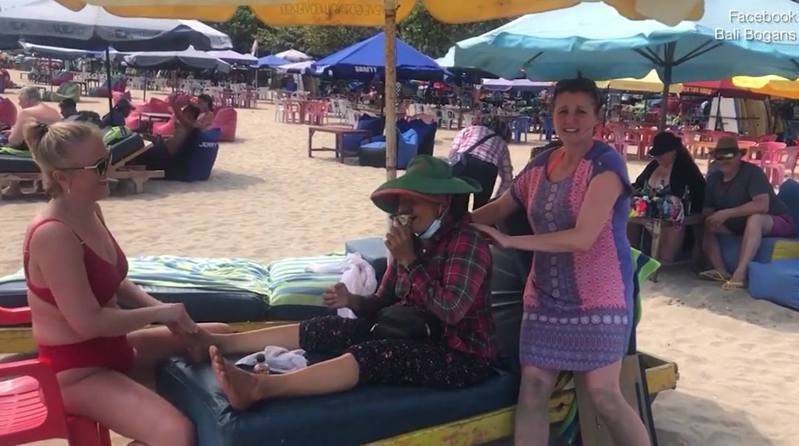 2名来自澳洲的女游客忽发其想，与在海滩工作的按摩女子对调角色，让对方感受一下当游客的感觉，获网民大赞「实在太赞了，你们做得好！」。（影片截图）(photo:UDN)