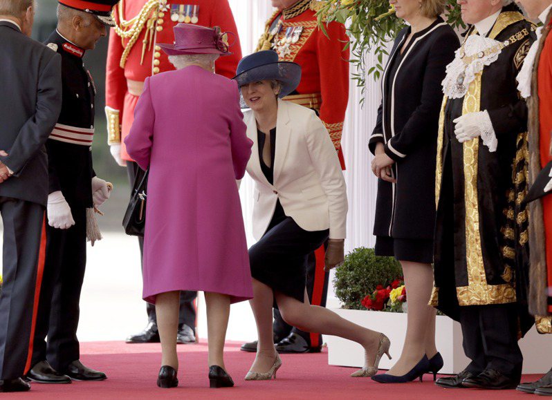梅伊（屈膝者）2017年7月12日陪同女王一起迎接西班牙国王伉俪访问英国。美联社(photo:UDN)