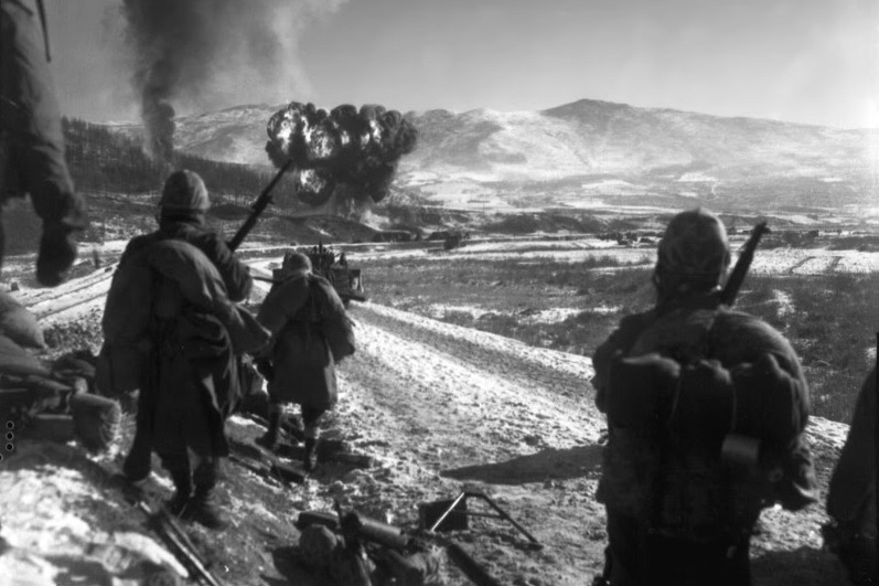 從長津湖突圍的美國陸戰隊官兵，戰機正對前方的解放軍據點投下汽油彈。圖／美軍檔案照