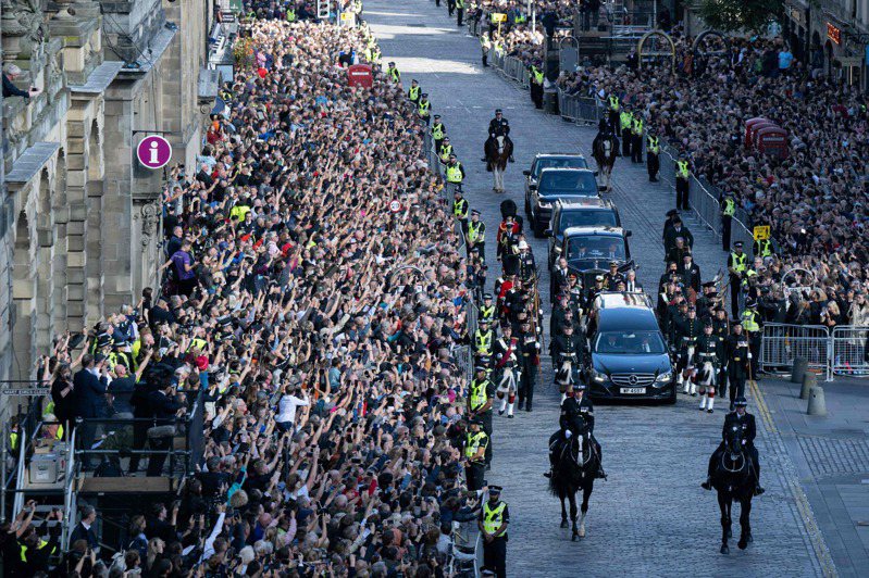 英國女王的靈柩車隊12日在蘇格蘭愛丁堡街頭前行，路旁擠滿人群。（法新社）