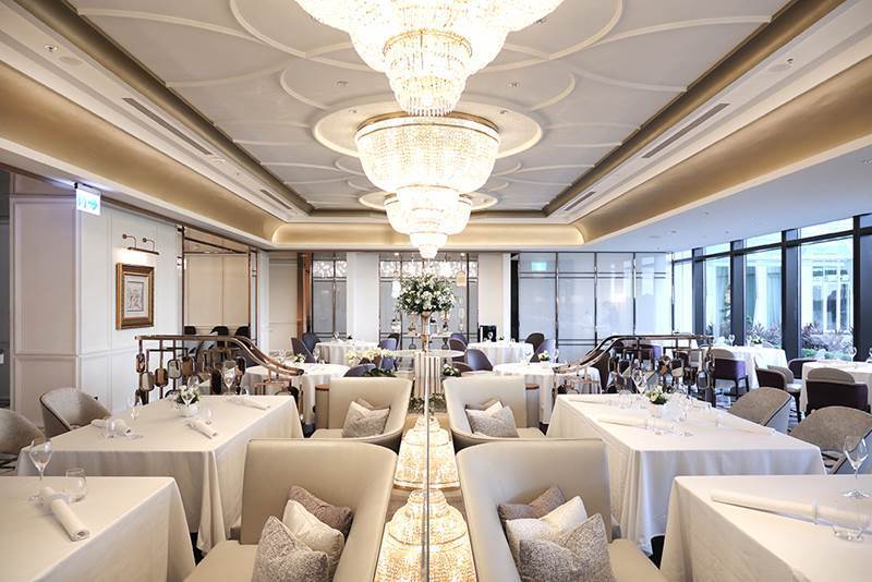 白與金構成明亮高雅的空間主調，垂吊的水晶吊燈下裝飾綻放的鮮花，「美享地餐廳」展現...