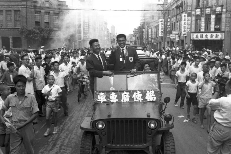 榮獲第17屆世運十項運動亞軍的中華民國選手楊傳廣，1960年9月15日搭機返國，楊傳廣（右）及他的家人，和一同在美國受訓的魏振武（左）教授，乘車遊行市區，接受民眾熱烈的歡迎。圖／聯合報系資料照片