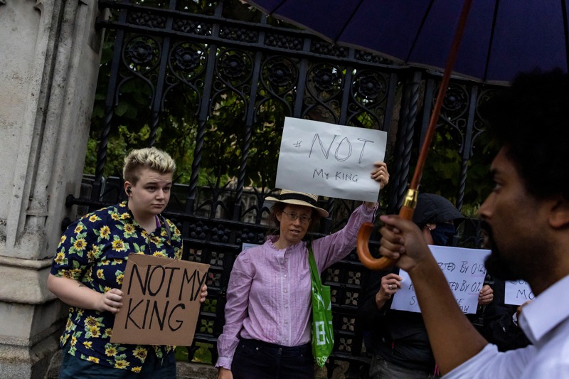 反王室人士13日持續在英國國會外手持「不是我的國王」海報抗議。路透