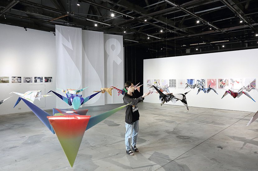 每一隻漂浮於空中的紙鶴，都是用藝術家創作的和平圖像摺成。 圖／Carter攝影