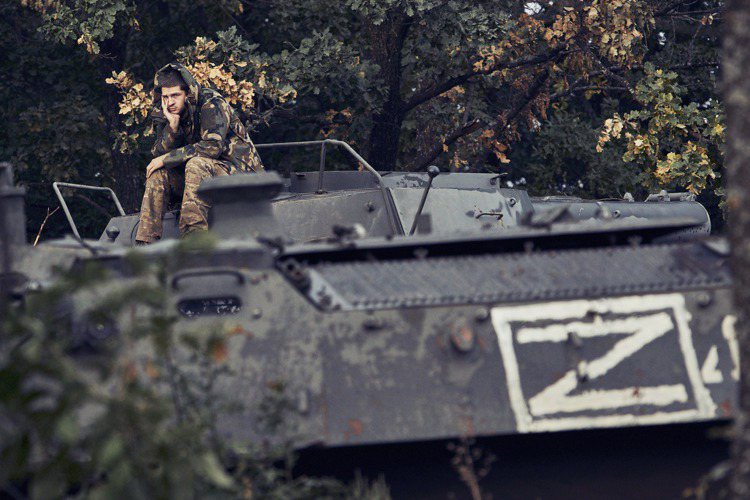 伊久姆郊外，烏軍士兵坐在繳獲的俄軍裝甲車上。