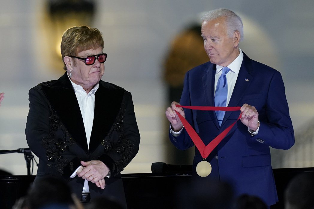 美國總統拜登（右）23日頒獎章給艾爾頓強（左）。（美聯社）