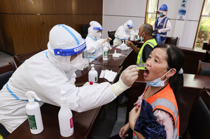 大陸各地執行嚴格的防疫政策，圖為海南海口某工地工人接受核酸採樣。（新華社）