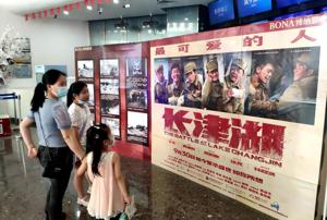 抗美援朝題材戰爭電影「長津湖」在中國大陸票房大賣，圖為民眾在福州一家電影院瀏覽「長津湖」宣傳海報。中新社