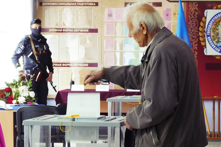 俄羅斯武裝軍人監視佔領區民眾投票。