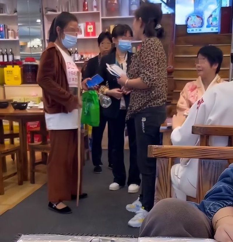 湖南湘西有兩人穿著和服用餐，遭一名大媽持長棍上前，要求兩人立刻脫衣，視頻在網路傳開。（視頻截圖）