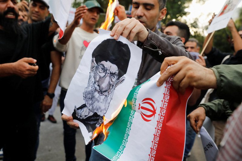 伊朗女子艾米尼因违反服装规定遭宗教警察逮捕后死亡，引发全国连日示威。图为民众在伊朗首都德黑兰街头示威。路透(photo:UDN)