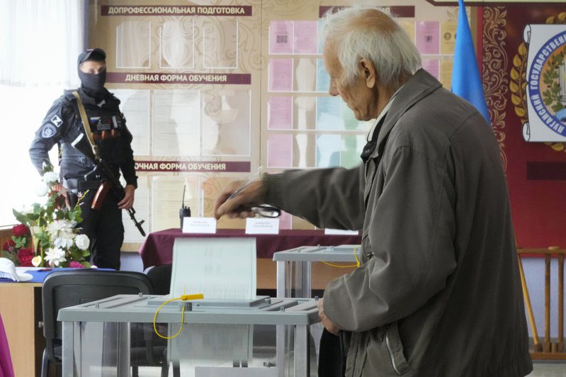 俄國在烏克蘭4個占領區舉行的入俄公投在27日結束，圖為當天一位民眾在盧甘斯克一處投票所內投票。美聯社