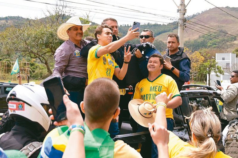 寻求连任的巴西总统波索纳洛（中）选前最后冲刺，跟支持者玩自拍。（法新社）(photo:UDN)