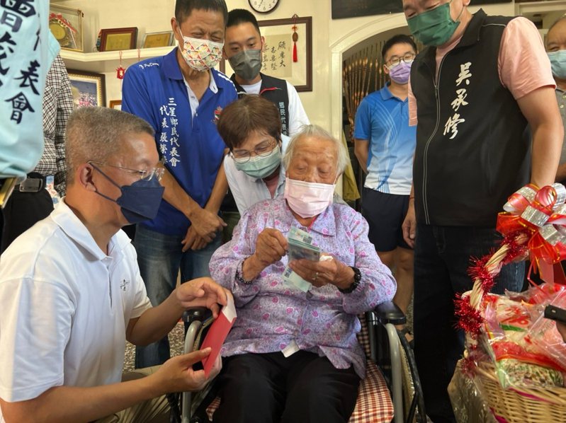 三星鄉111歲人瑞陳阿燕女士的腦筋還很好，她收下三星鄉長李志鏞送上的敬老金，當場點數鈔票，超可愛。圖／鄉公所提供