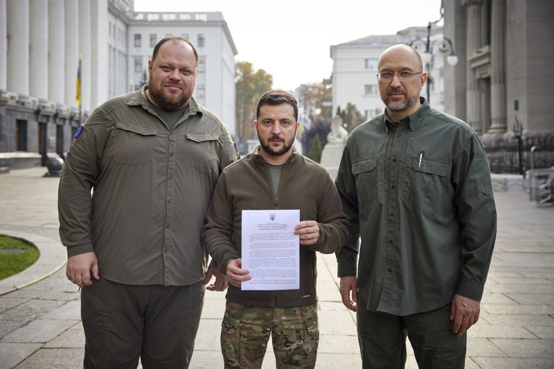 烏克蘭總統澤倫斯基（中）9月30日在總理什米加爾（右）和國會議長斯特凡楚克陪同下，於基輔拿著入會申請書，要求快速加入北約。 美聯社
