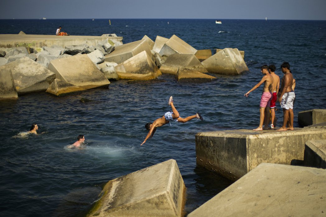 西班牙巴塞隆納年輕人在地中海跳水避暑，此為示意圖。（美聯社）