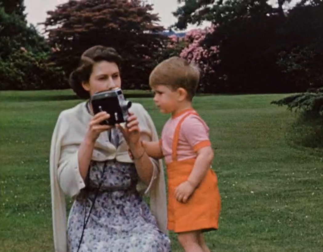 伊麗莎白二世拿著16mm錄影機為查爾斯三世拍照。 圖／《伊麗莎白九十歲：家的禮讚...