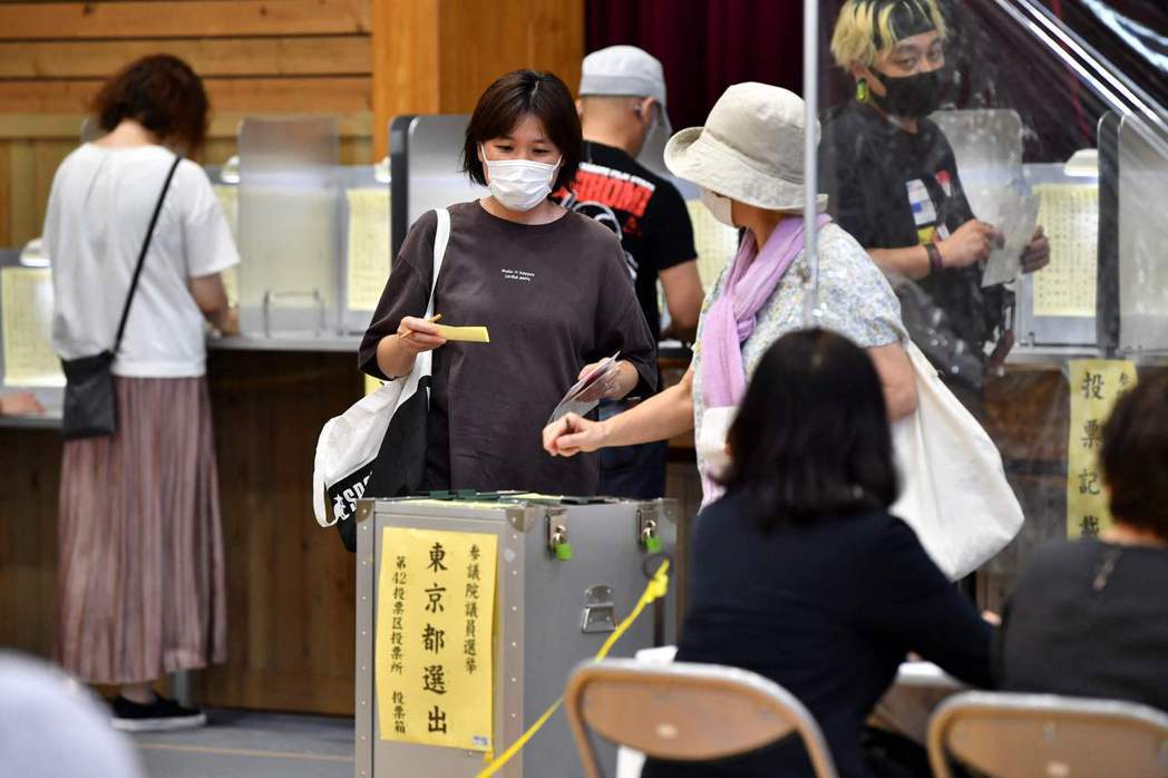 日本民眾今年7月10日參議院選舉當天在東京一處投票站投票。圖為投票示意圖，非確診選民。 圖／法新社