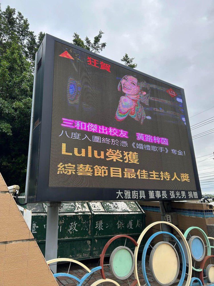Lulu的國小母校在電視牆上放照片狂賀。 圖／擷自臉書