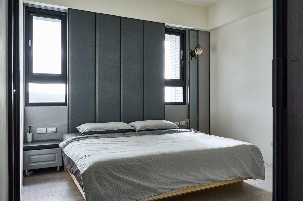 主臥室運用床頭繃布隱藏門遮蔽後方的窗戶，鋪陳低調輕奢的飯店風。