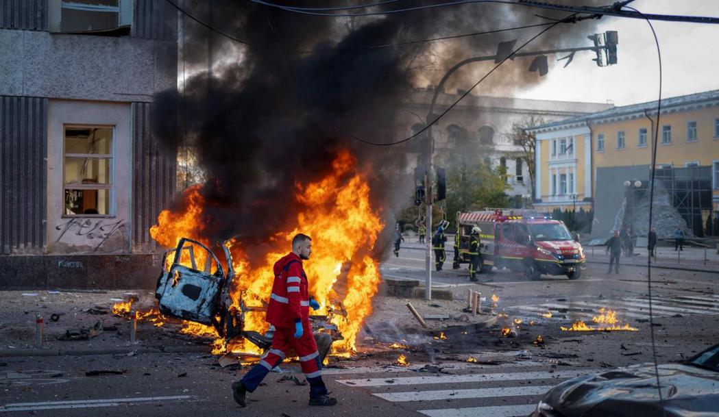 10月10 日，俄羅斯在烏克蘭基輔發動襲擊。一名醫務人員跑經一輛燃燒的汽車。 圖...