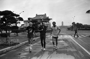 1977年11月4日，台灣省體育會高齡長跑協會總幹事劉季堯（中）清晨6時陪同美國高齡田徑協會選手鮑爾（左）及歐尼爾（右）從國賓大飯店跑步至台灣大學，中途經過總統府前的景福門。圖／聯合報系資料照片