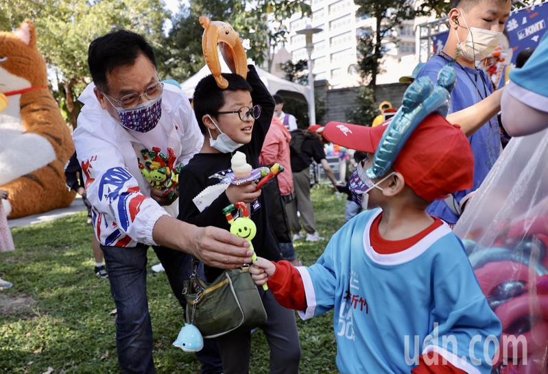 國民黨新竹市長候選人林耕仁（左）下午在龍山公園舉辦親子園遊會，他發送糖果給小朋友，並宣傳自己的育兒政策。記者許正宏／攝影