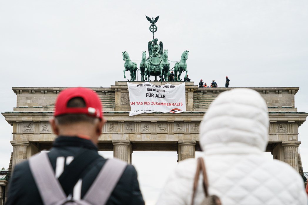 圖為兩名「Letzte Generation」成員在柏林布蘭登堡門上的抗議行動遭警方包圍。 圖／歐新社