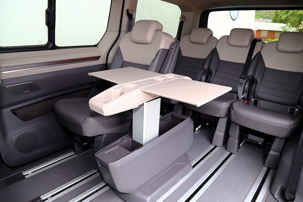 中央滑軌的鷗翼式多功能桌，相比過往福斯商旅Multivan只能在第二排座椅的使用...