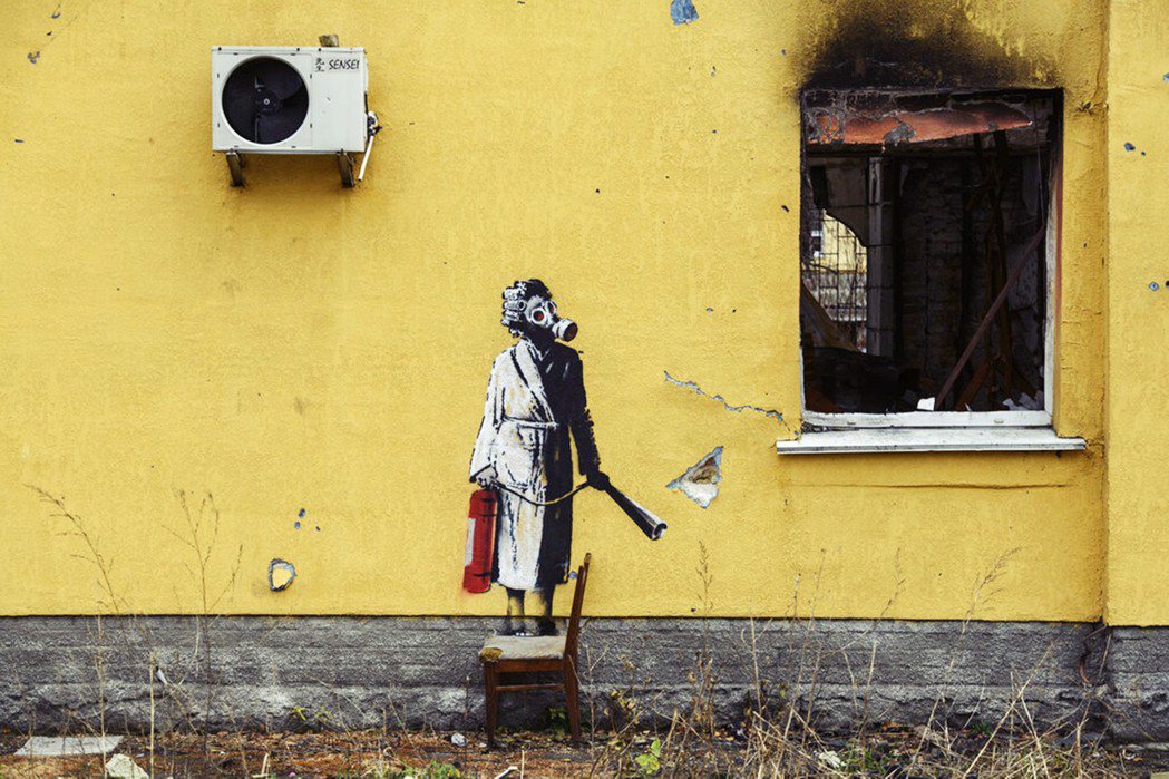 一名身穿睡衣的女子戴著防毒面具、手拿滅火器的塗鴉。 圖／美聯社