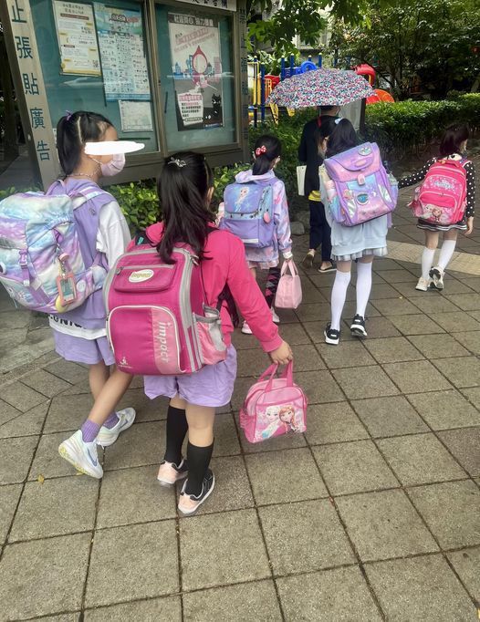 照片中最左邊的那位小女生，全身上下包含書包、衣服及鞋襪一整套都是「名牌」精品。 圖擷自路上觀察學院