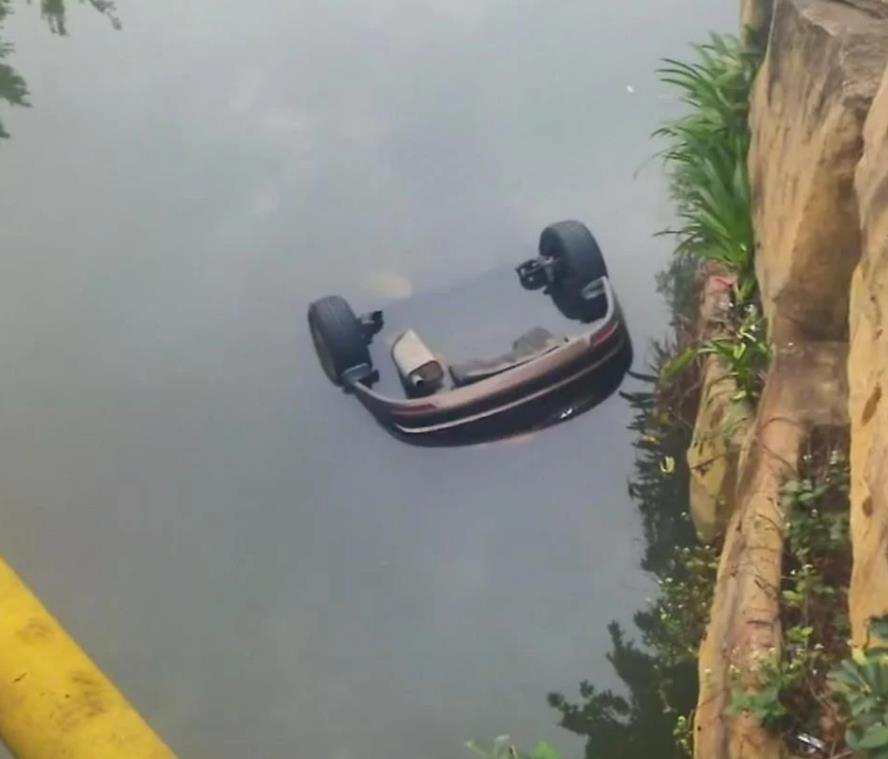被扔進河中的車已完全泡在水中。（上游新聞）