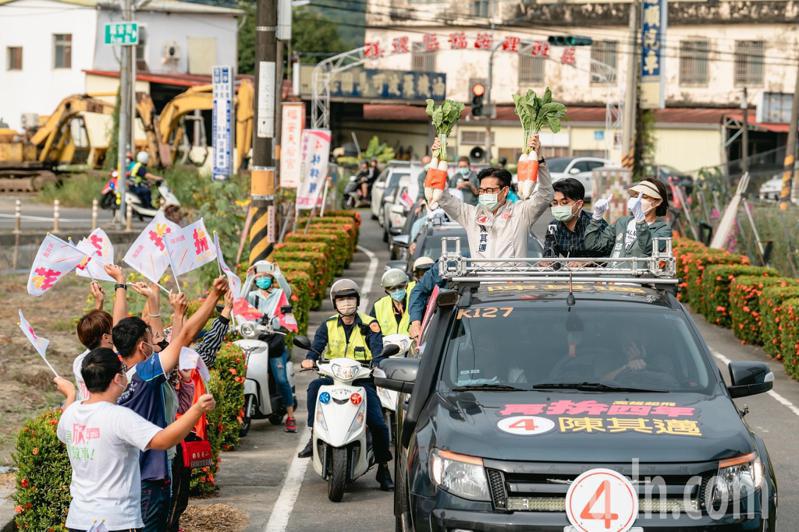 高雄市長陳其邁（車上左）拚連任，今整天都在東高雄車掃，在美濃有支持者熱情送上菜頭。圖／陳其邁競總提供