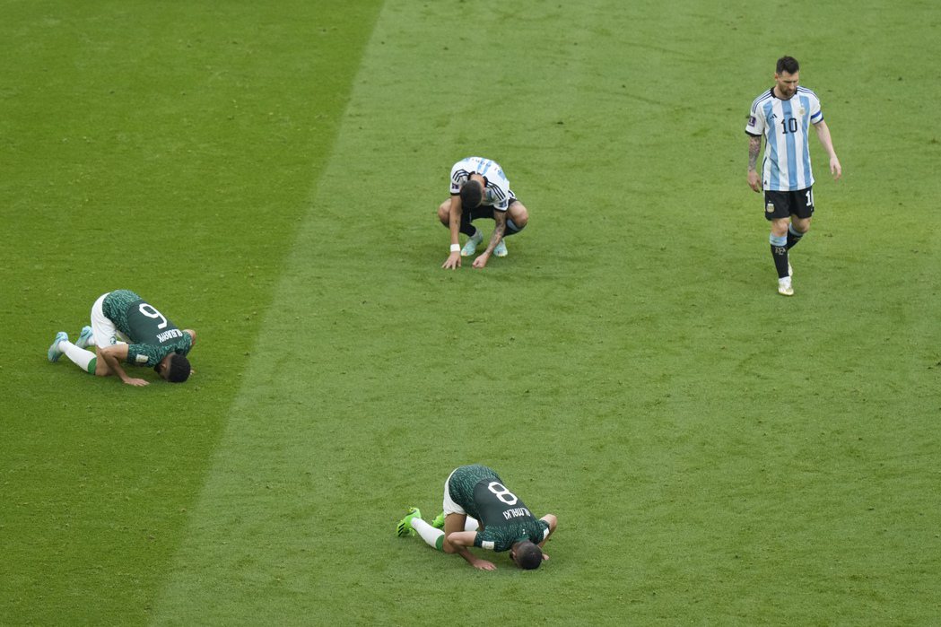 球賽結束後，狂喜跪地的沙烏地球員與惱恨的阿根廷球員。 圖／美聯社