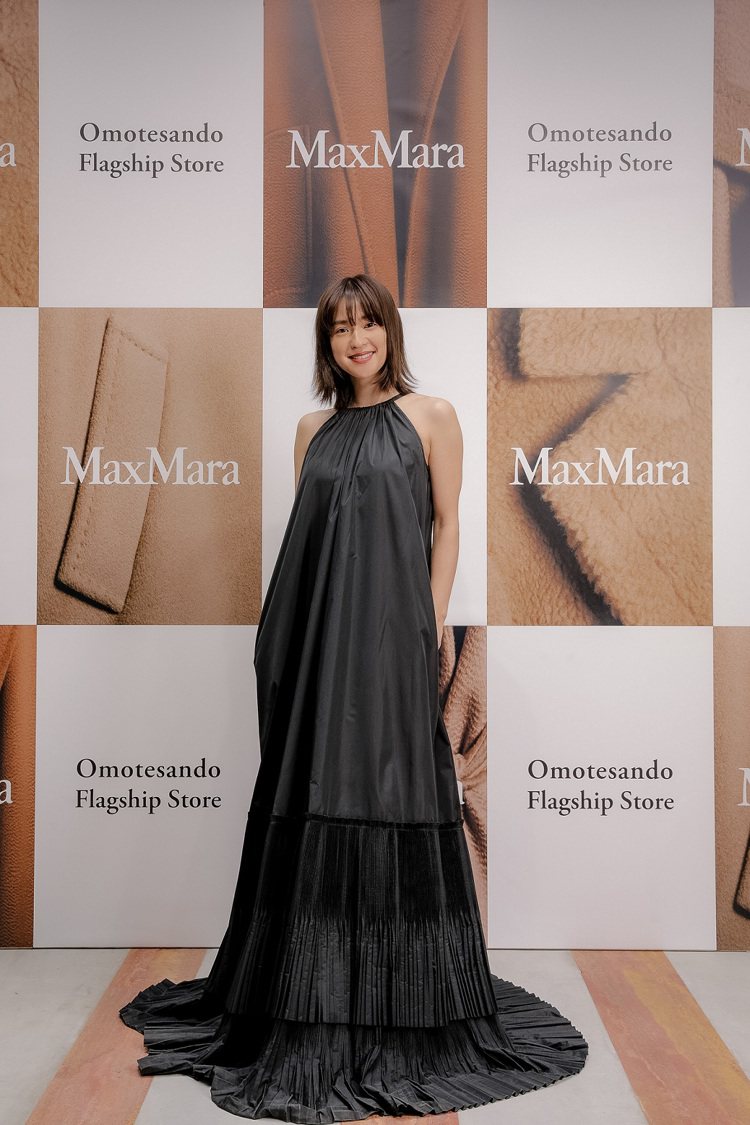 中村杏（Anne Nakamura）的削肩黑色長洋裝裙擺尾端更有著細膩的皺褶設計...