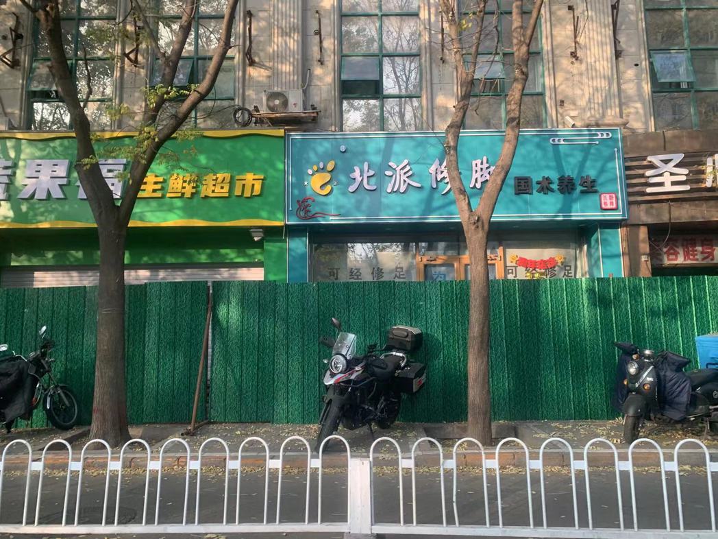北京疫情嚴峻，朝陽區一出現感染者的住宅樓和樓下商店，都遭到封控管理，被鐵皮柵欄圍...