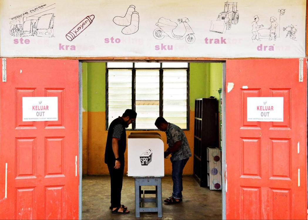 馬來西亞選舉工作人員在19日大選前夕，在投票所做最後準備工作。 圖／路透社　