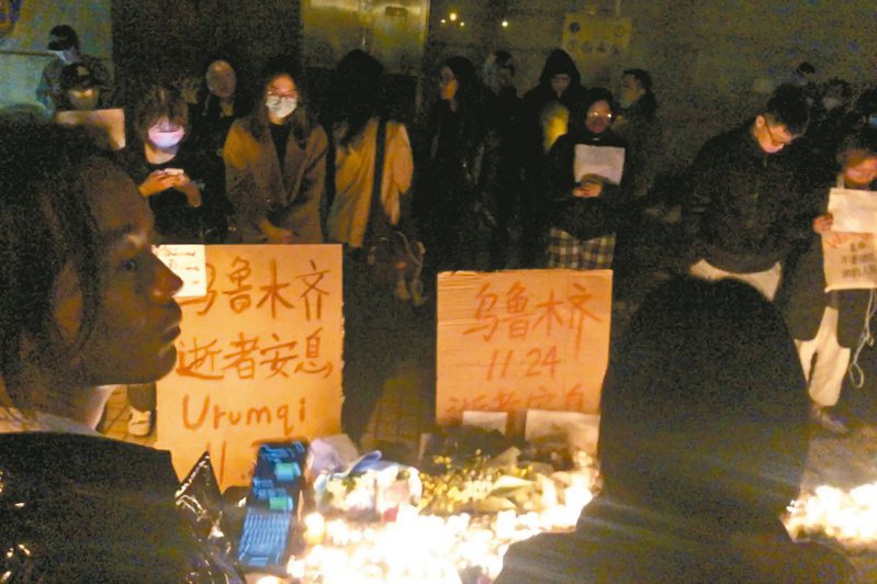 上海燭光會 悼新疆罹難者 數百名上海市民廿六日夜間聚集在烏魯木齊中路舉行燭光晚會，悼念新疆火災死難者，並提出「要解封」及「不要核酸要自由」等訴求。（美聯社）