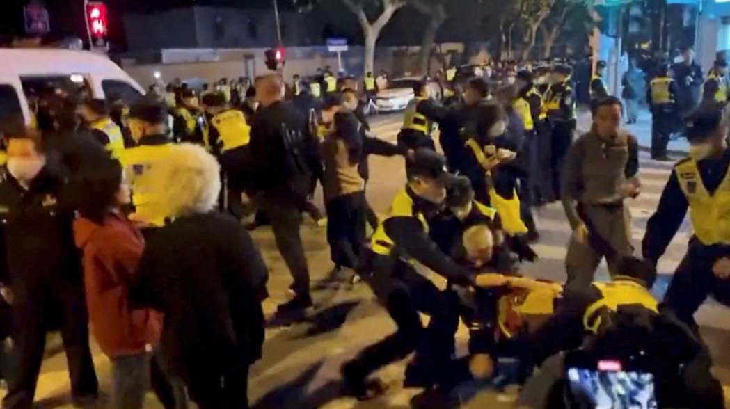 警方毆打上海的抗爭者。 圖／路透社