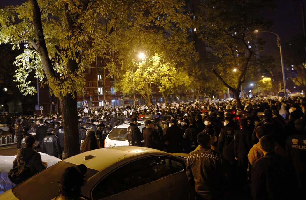 11月27日，北京的大批抗爭者，與一旁待命的警方。 圖／歐新社
