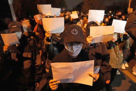 11月27日，北京手舉白紙的抗爭者。 圖／美聯社
