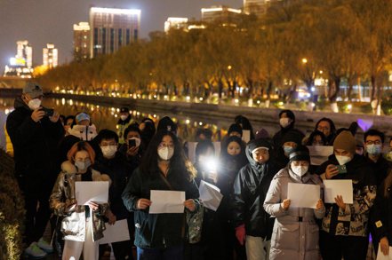 北京民眾舉行燭光晚會悼念新疆火災死難者，一面舉白紙表達要求當局結束封控的訴求。路透