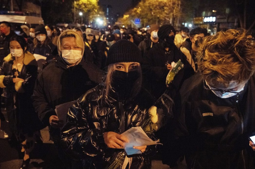 圖為11月27日晚間，在北京亮馬橋附近的白紙抗議現場，非本文當事人。 圖／歐新社