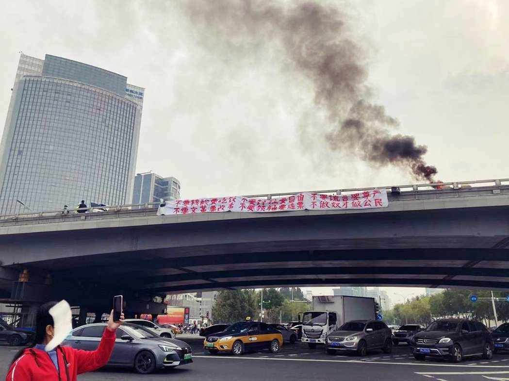 北京四通橋上出現一條橫幅白布條，紅字寫著「不要核酸要吃飯，不要封控要自由」等標語...