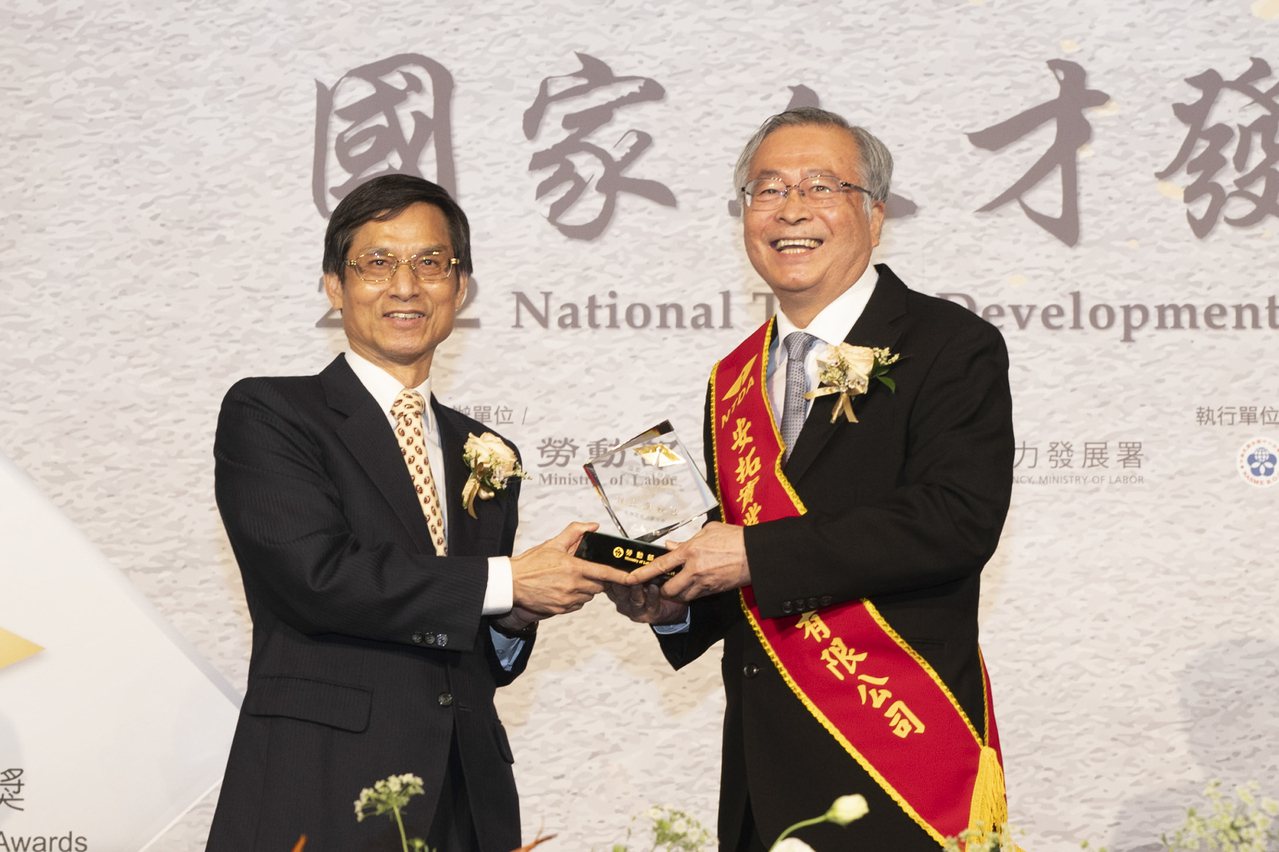 由行政院政務委員林萬億（左）頒獎，安拓實業總經理朱碧峰（右）代表受獎。