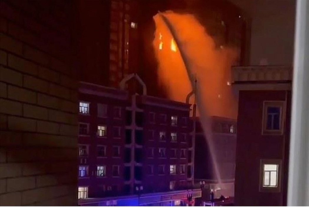 新疆維吾爾自治區烏魯木齊消防員11月24日在一棟住宅樓中噴水滅火。美聯社